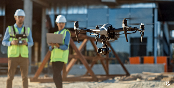 Several people on a job site using a streaming-enabled drone to survey.