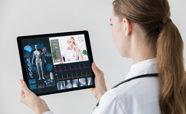 Doctor consulting with patient via live stream with comprehensive, dynamic data such as blood pressure appearing within the platform