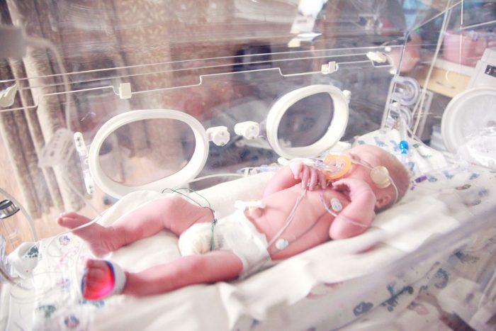 Newborn Baby in NICU with biomedical devices used to collect real-time data.